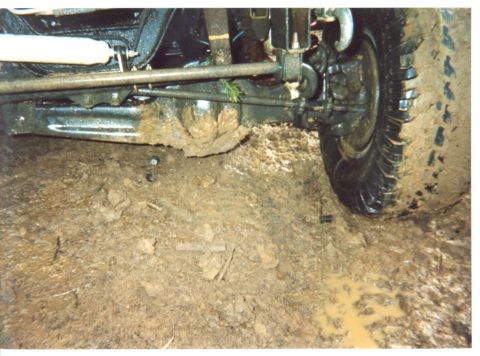 1989 Ford Bronco - Spring, u-joint cap, and end of the axle in the mud