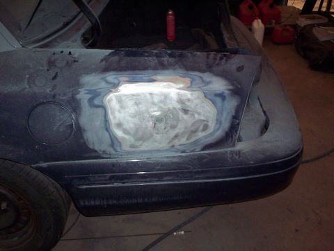 1998 Ford Crown Victoria - Bodywork in progress on a dark blue car's rear quarter panel.