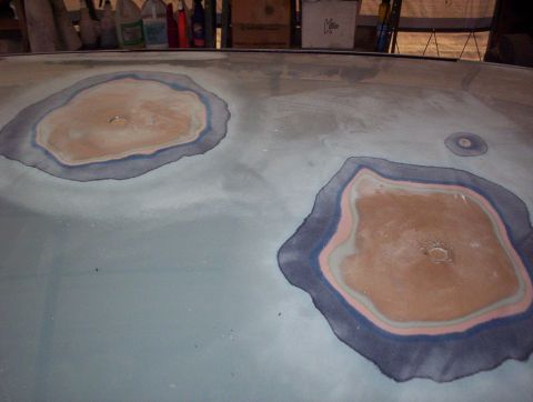 1998 Ford Crown Victoria - Body filler applied to repair damage on a car hood, showing multiple layers of material.