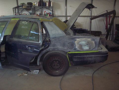 1998 Ford Crown Victoria - A 1998 Ford Crown Victoria is seen in a workshop with its hood and trunk open, undergoing repairs and bodywork repairs.