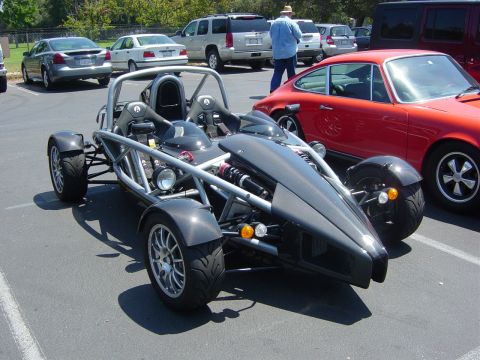 1993 Ford Probe - Ariel Atom sports car parked in a lot with other vehicles, including a red Porsche.