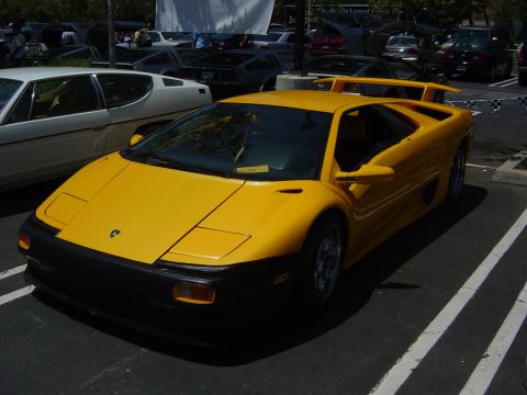 1993 Ford Probe - A yellow Lamborghini Diablo is parked in a lot with other vehicles visible.