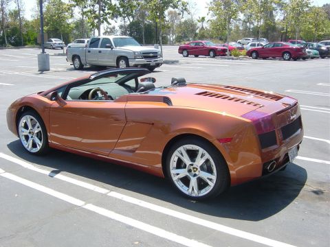 1993 Ford Probe - Orange convertible sports car in a parking lot with other vehicles visible.