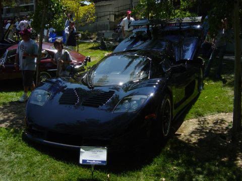 1993 Ford Probe - A dark blue sports car is displayed outdoors with its hood and doors open, attracting attention.