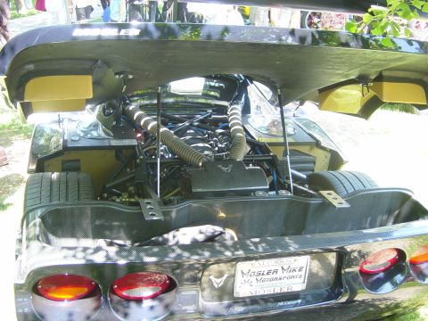 1993 Ford Probe - Rear view of a Mosler sports car with its engine exposed, revealing a V8 engine and carbon fiber components.