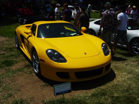 1993 Ford Probe - A yellow Porsche Carrera GT is displayed at an outdoor car show.