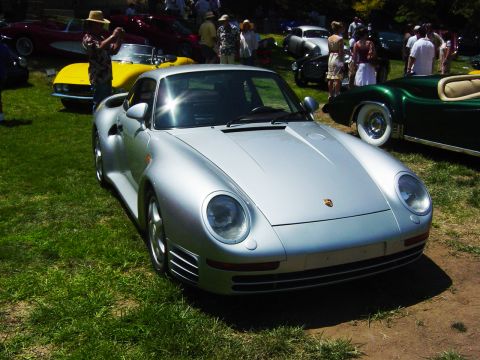1993 Ford Probe - A silver Porsche 959 is the main focus at an outdoor car show with other vehicles and attendees present.