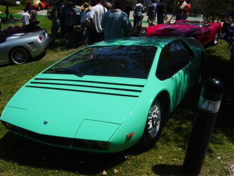 1993 Ford Probe - A teal sports car with distinctive black stripes on its hood is displayed outdoors among other vehicles.