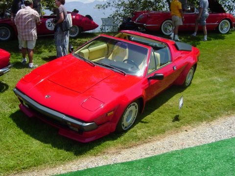1993 Ford Probe - A red sports car is displayed on a grassy lawn with other vehicles in the background.