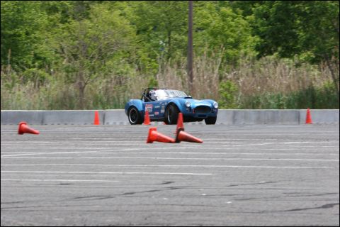 2001 Mercury Grand Marquis - A blue convertible sports car is seen maneuvering through an autocross event, indicated by the presence of orange cones on the track.