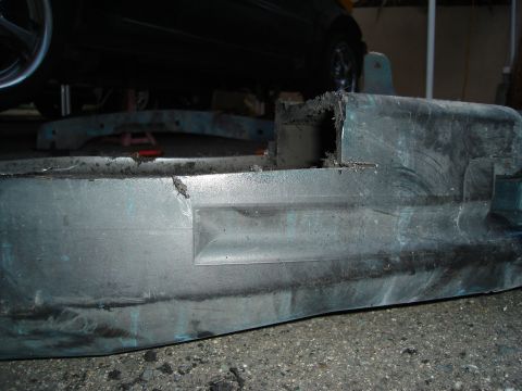1995 Mazda MX-6 - Close-up of a damaged car bumper, showing wear and tear.