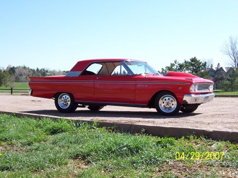 1994 Ford Bronco - This red coupe features a prominent hood scoop and drag-style wheels, captured on a sunny day.