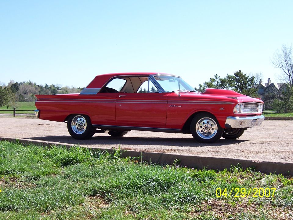 Red coupe with hood scoop and drag wheels, side view