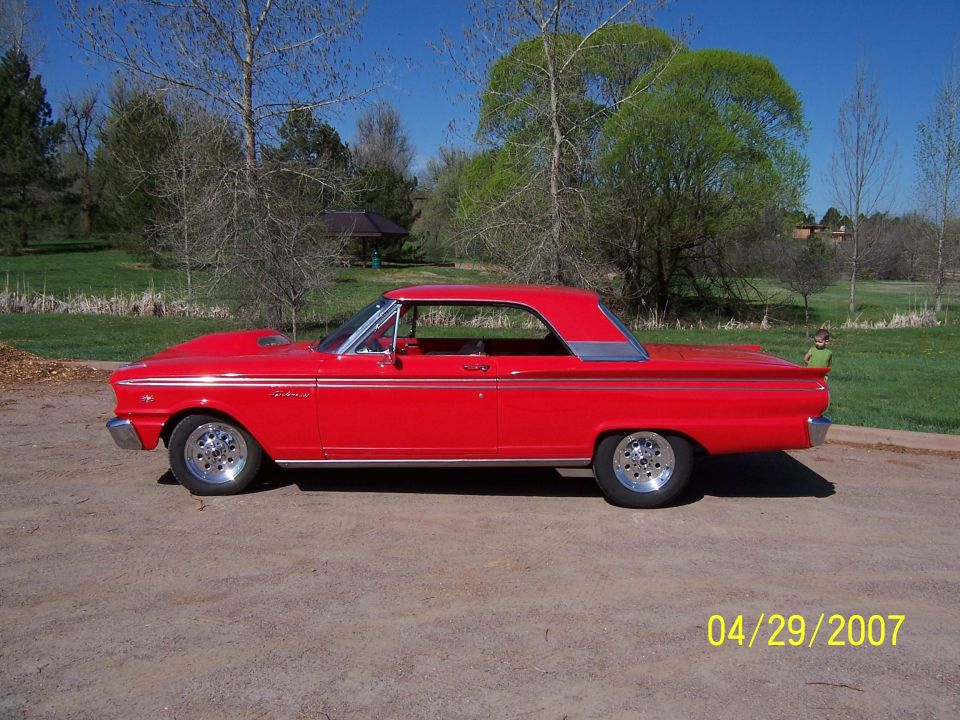 Red 1963 Ford Falcon two-door hardtop with custom wheels parked outdoors