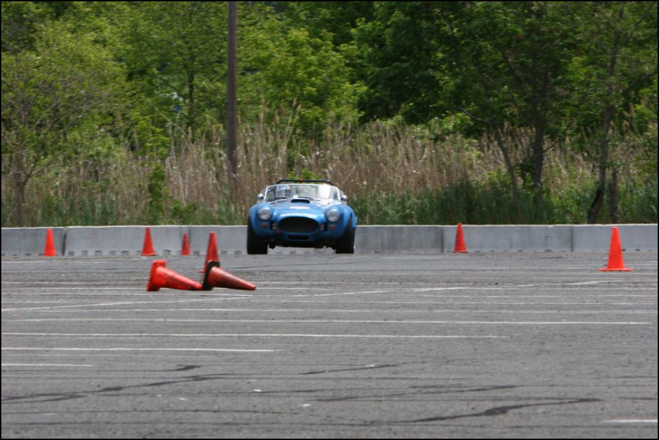 Blue AC Cobra replica navigating an autocross course with orange cones