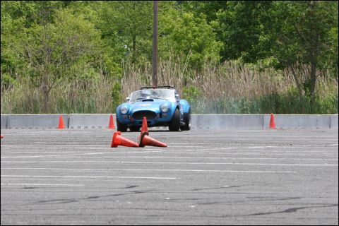 2001 Mercury Grand Marquis - A blue convertible sports car navigates an autocross course marked by orange cones.