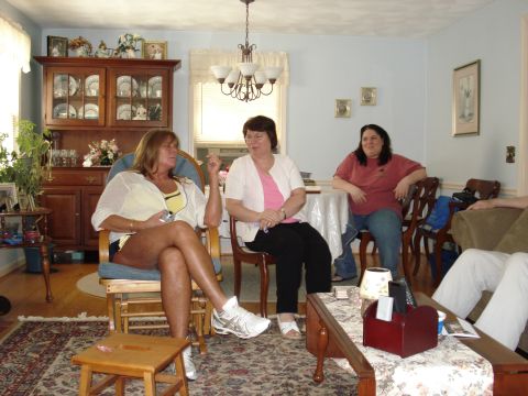 2000 Ford Crown Victoria - A casual gathering of three women in a home setting, with furniture and decor suggesting a relaxed atmosphere.