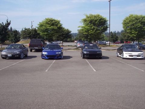 1995 Ford Probe - A row of cars, including a 1995 Ford Probe, are parked in an outdoor lot on a sunny day.