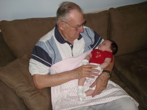 2000 Ford Crown Victoria - A grandfather cradles his sleeping grandchild, a tender moment captured on camera.