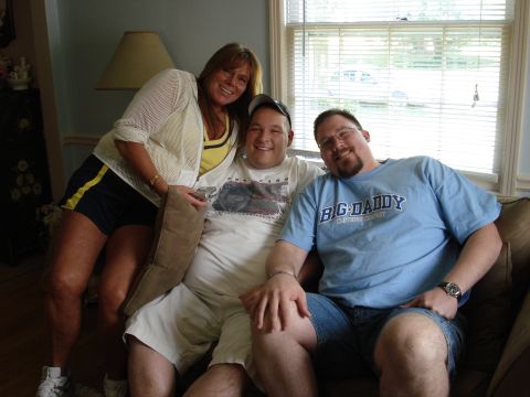 2000 Ford Crown Victoria - Three people pose for a photo while sitting on a couch indoors.