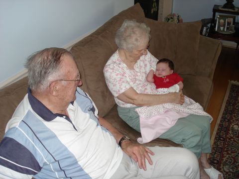 2000 Ford Crown Victoria - A family gathers on the couch, with a grandmother holding a baby while a grandfather looks on.