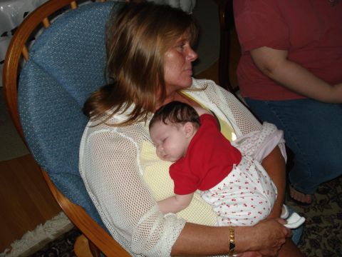 2000 Ford Crown Victoria - A woman cradles a sleeping infant in her arms while seated in a chair.