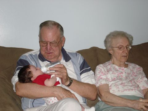 2000 Ford Crown Victoria - Grandfather feeds a baby from a bottle while grandmother looks on.