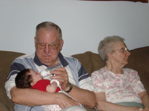 2000 Ford Crown Victoria - A grandfather feeds a baby from a bottle while a grandmother watches.