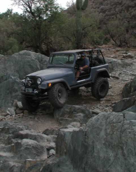 1983 Jeep CJ7 - A gray 1983 Jeep CJ7 tackles a challenging rocky off-road course.