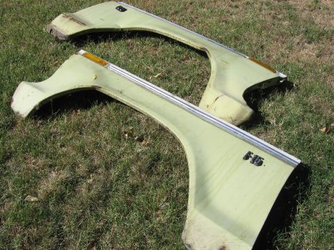 1989 Ford Bronco - Two light green fenders with "F15" emblem and amber turn signals lie on the grass.