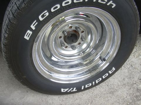 1997 Ford Crown Victoria - A close-up view of a shiny chrome wheel with white lettered BFGoodrich Radial T/A tires.