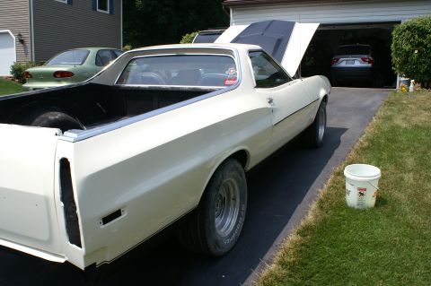1972 Ford Ranchero - A white 1972 Ford Ranchero is parked in a driveway with its hood up, alongside another car and a garage.