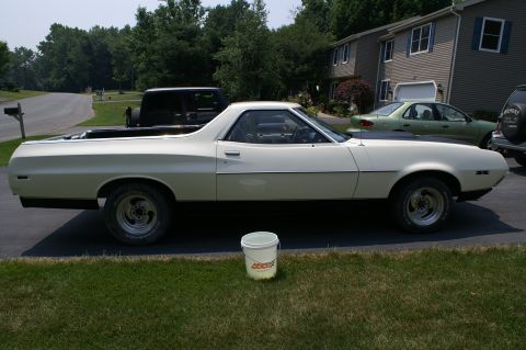 1972 Ford Ranchero - A white 1972 Ford Ranchero pickup truck is parked in a driveway next to other vehicles.