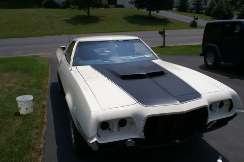 1972 Ford Ranchero - A white 1972 Ford Ranchero with a black hood scoop and stripe is parked in a driveway next to a dark SUV.