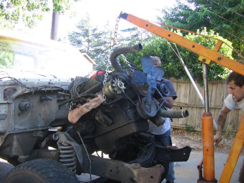 1989 Ford Bronco - Engine removal in progress with an engine hoist.