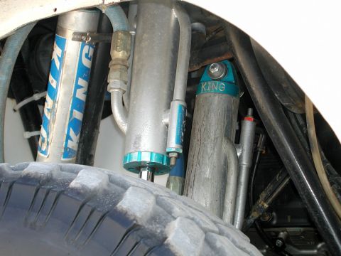 2000 Ford F-150 - Multiple King brand shocks are visible near a tire, suggesting an off-road vehicle modification.