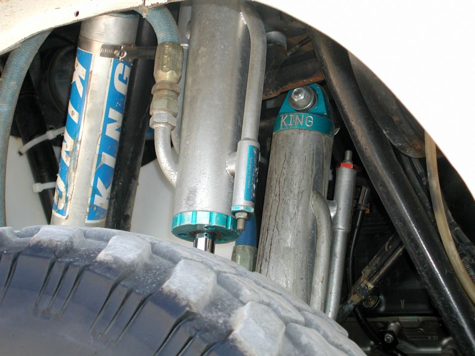 Close-up of multiple King shocks and a tire, likely for off-road use