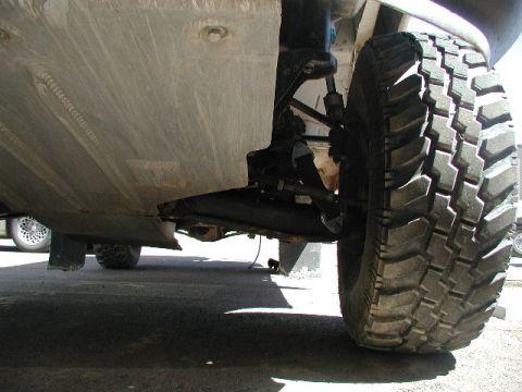 2000 Ford F-150 - A low-angle view of a truck's undercarriage, focusing on the suspension and wheel assembly.