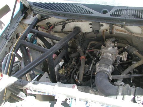 2000 Ford F-150 - Engine bay of a 2000 Ford F-150, a roll cage and visible engine components.