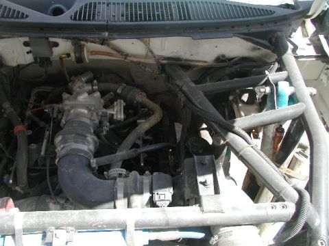 2000 Ford F-150 - The engine bay of a vehicle, showing complex wiring and plumbing, with a roll cage structure present.