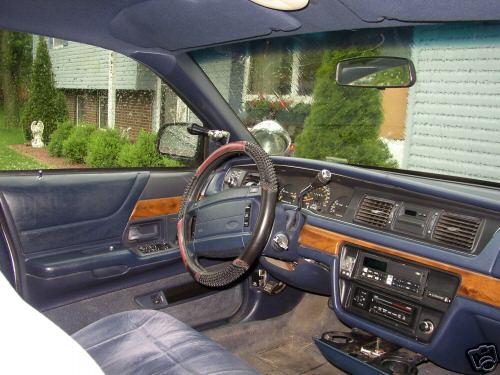 Blue interior of a sedan showing dash, wood trim, and steering wheel