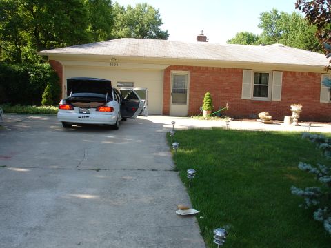 1993 Ford Taurus - A white 1993 Ford Taurus is parked in a driveway with its trunk and driver's door open.