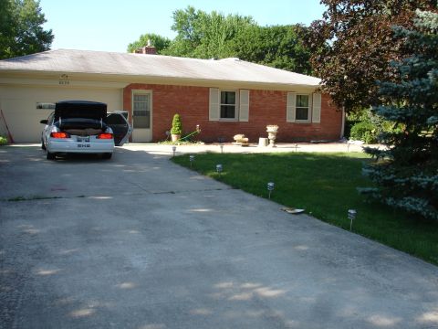 1993 Ford Taurus - A white sedan is parked in a driveway with its trunk open, in front of a brick house.