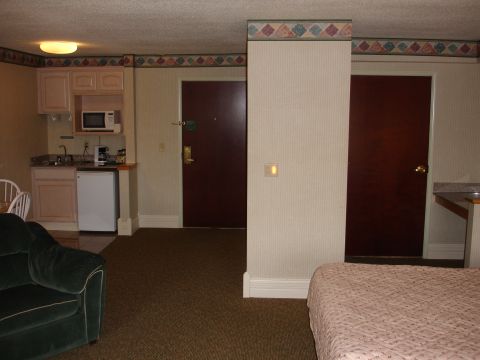 1993 Ford Taurus - Interior view of a hotel room a kitchenette, seating area, and a bed.