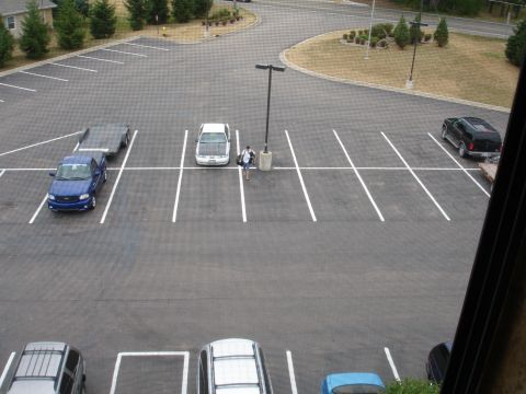 1993 Ford Taurus - A parking lot contains a blue pickup truck with a trailer, a white sedan, and a black SUV.