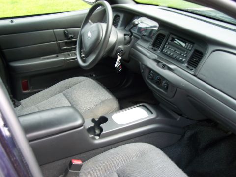 2003 Ford Crown Victoria - The interior of a 2003 Ford Crown Victoria, the dashboard, steering wheel, and front seats.