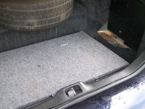 2003 Ford Crown Victoria - Spare tire and carpeted floor visible in the trunk of a vehicle.