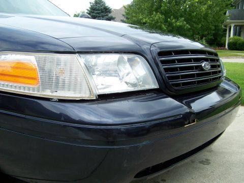 2003 Ford Crown Victoria - Front view of a dark blue 2003 Ford Crown Victoria, showing the grille and headlights.