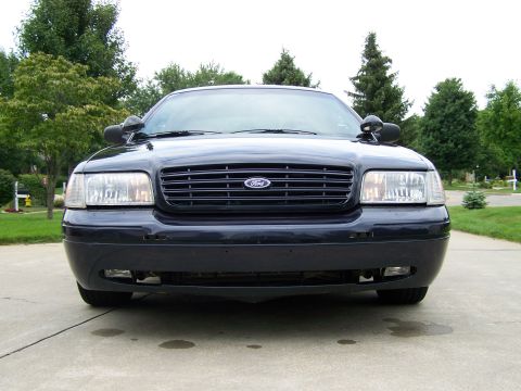 2003 Ford Crown Victoria - Frontal view of a dark blue 2003 Ford Crown Victoria, showing its grille and headlights.