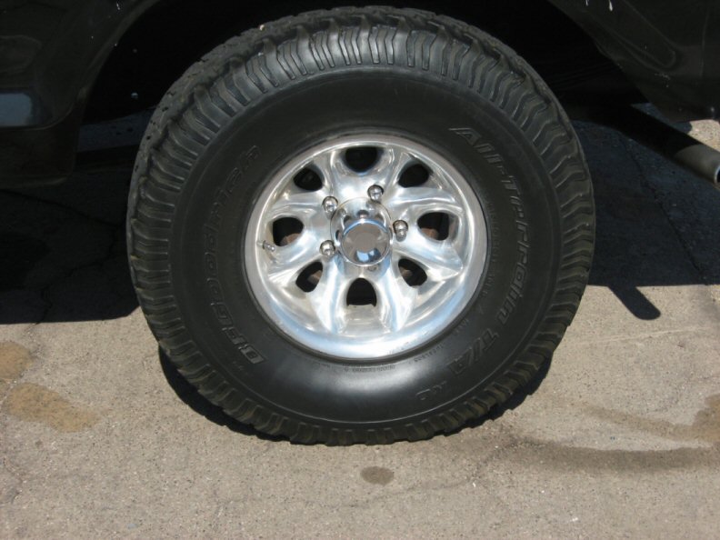 Polished aluminum wheel with BFGoodrich All-Terrain T/A tire on a dark vehicle